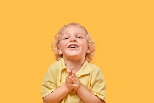 Engraçado lindo menino loiro em um fundo amarelo olha para a câmera. — Fotografia de Stock