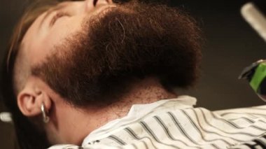 Sakal bırak. Barber 'ın bir müşterinin sakalını makasla keserken yakın plan fotoğrafı..