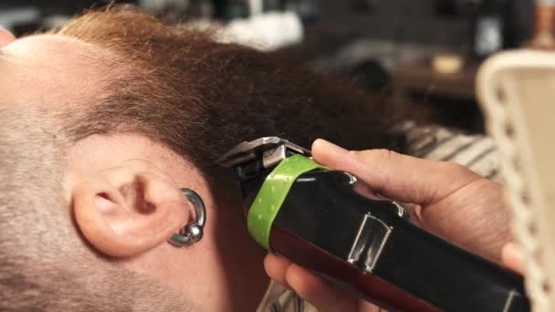 Fryzjer obcina klientom długą brodę maszynką do strzyżenia. Modne wykończenie brody. — Wideo stockowe