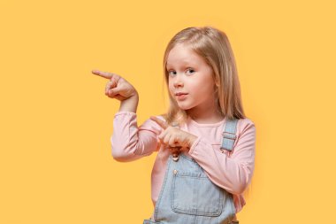 Sarışın bir kız kameraya bakar ve soldaki boş yeri gösterir..