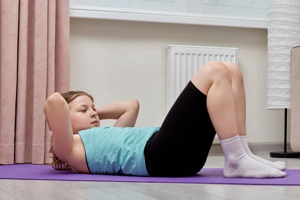 Cute beautiful girl performs abs exercises at home. — Stock Photo, Image