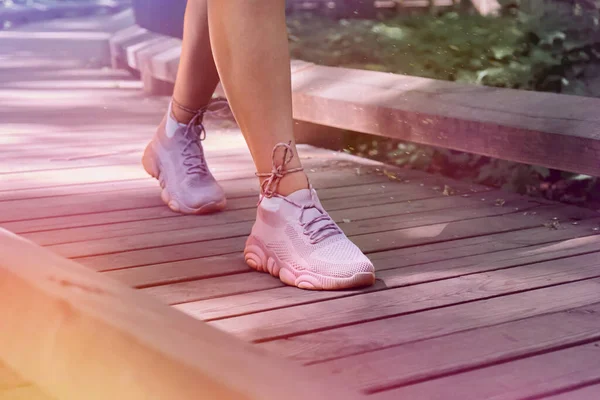 Vrouwen voeten in roze sneakers, rennend op een pad in het bos. — Stockfoto