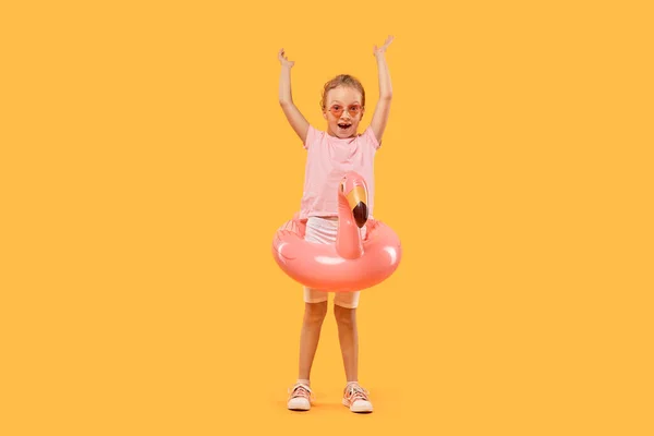 Flamingo 모양의 수영 원을 가진 선글라스를 낀 행복 한 소녀. — 스톡 사진