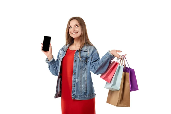 Młoda uśmiechnięta kobieta robi zakupy online ze smartfonem w rękach. — Zdjęcie stockowe