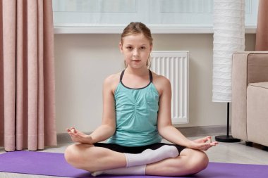 Mat marka mor bir spor ayakkabısında oturan güzel kız yoga yapıyor..