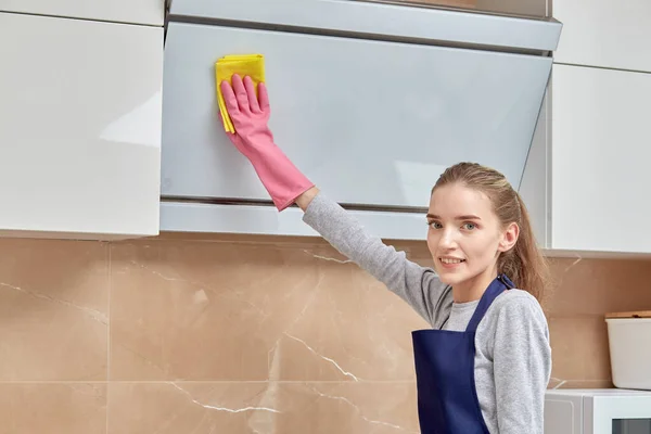 Womens hands in pink gloves doing cleaning in the kitchen. Modern kitchen.
