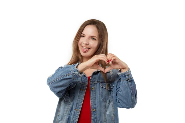 Leuke jonge vrouw toont tong en symbool van hart en liefde. — Stockfoto