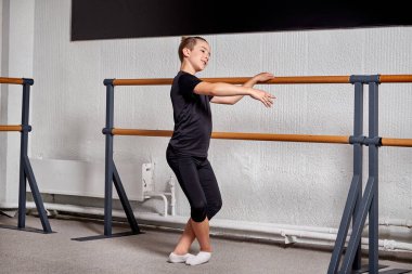 Spor elbiseli yakışıklı adam sınıfta bale yapıyor..