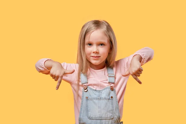 Das kleine blonde Mädchen zeigt mit der Hand nach unten. — Stockfoto