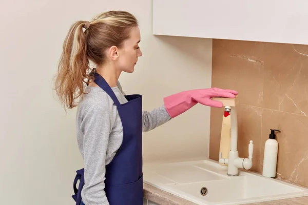 Mujer lava el lavabo con una esponja en la cocina con agente limpiador. — Foto de Stock