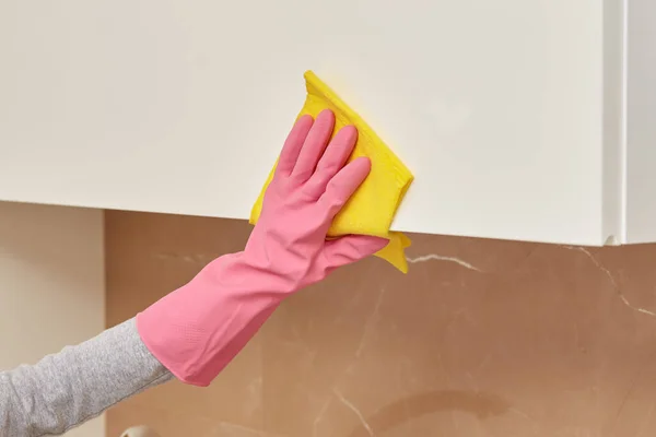 Vrouwen handen in roze rubberen handschoenen doen de reiniging met een gele servet. — Stockfoto