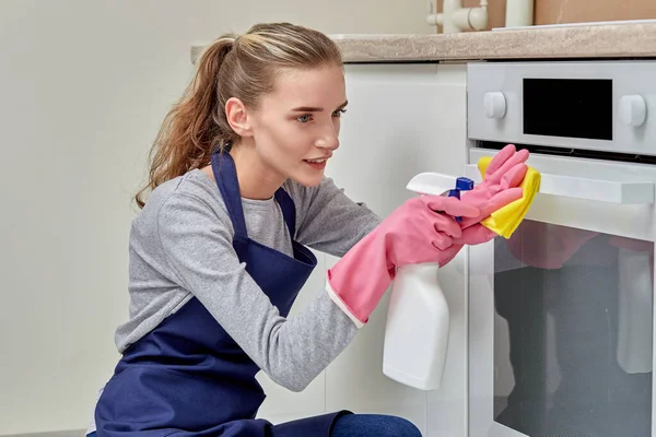 女性は台所をきれいにし、ナプキンで電気ストーブを洗う. — ストック写真