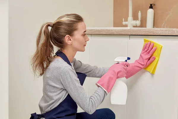 Una mujer con guantes de goma está limpiando la cocina. Rutina doméstica. — Foto de Stock