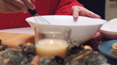 Kadınların elleri hamuru hazırlar, zencefilli Noel kurabiyeleri için çırpıcıyla karıştırır.
