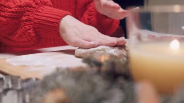 Kırmızı kazaklı kadınların elleri Noel kurabiyeleri için hamur hazırlıyor..