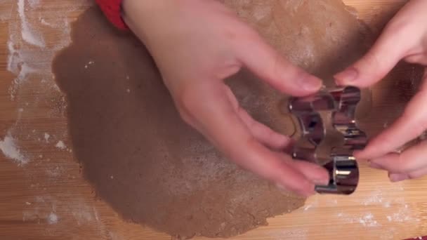 Női kéz készít mézeskalács cookie-k segítségével fém cookie vágó. — Stock videók