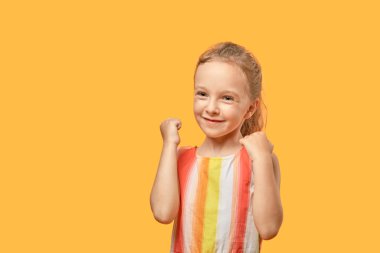 Yan tarafa bakan mutlu sarışın kız. Turuncu izole arkaplan.