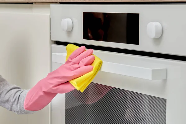 オーブンを洗うマイクロファイバークロスでゴム手袋の手のクローズアップ. — ストック写真