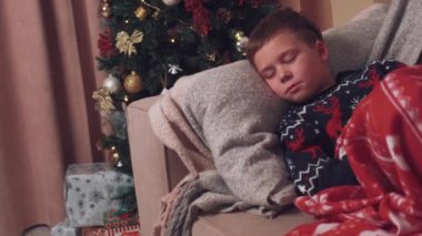 Çocuk Noel sabahını beklerken kanepede uyuyakaldı..