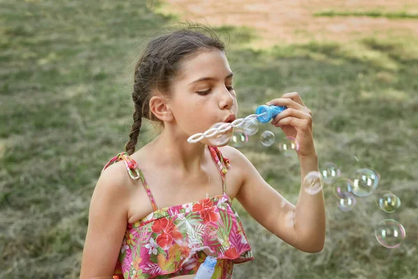 여름 방학중인 한 어린 소녀가 비누 방울을 터뜨린다. — 스톡 사진