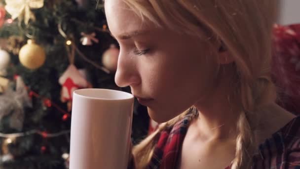Genç ve güzel bir kadın lezzetli bir sıcak içeceğin kokusunu alır.. — Stok video