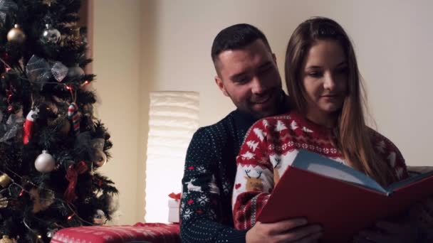 Un hombre da un regalo en una caja con un lazo a su amada mujer en el día de Navidad. — Vídeo de stock