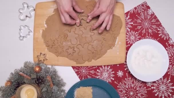 Vrouwen handen gesneden koekjes uit dun deeg met behulp van koekjesvormen. — Stockvideo