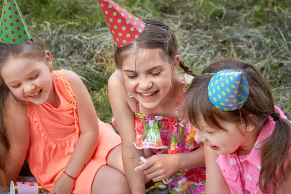 Söta flickor i en festlig hatt, med fest visselpipor och ljusa klänningar. — Stockfoto