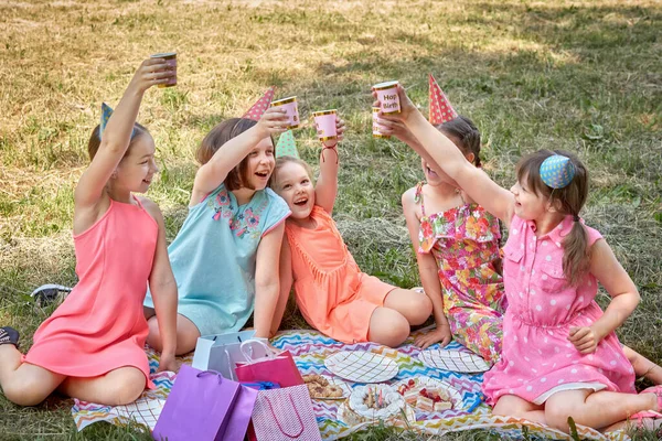 Девушка в шляпе для вечеринок празднует день рождения со своими друзьями. — стоковое фото