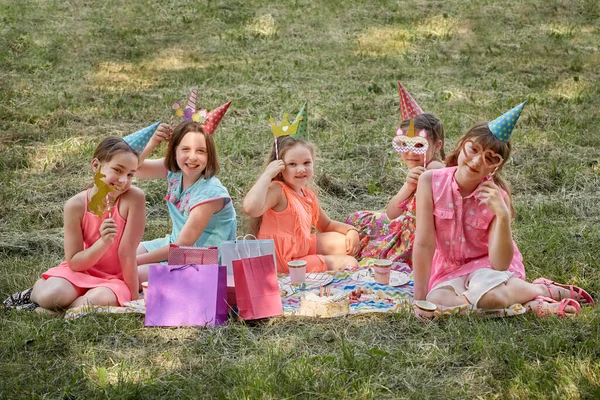 Маленькие девочки на пикнике празднуют свой день рождения в карнавальных масках. — стоковое фото