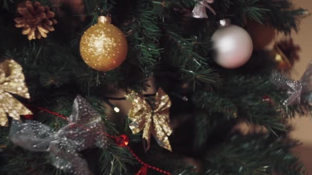 Seorang anak laki-laki di rumah menghias pohon Natal dengan mainan eko terbuat dari merasa. — Stok Video