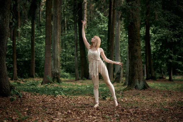 Blonde pieds nus dansant dans une forêt dense en été. — Photo