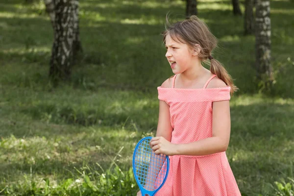 Şirin bir kız elinde badminton raketiyle arkadaşını arıyor..