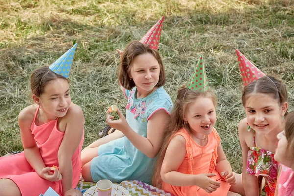 Flickor firar sin födelsedag och äter godis med händerna. — Stockfoto
