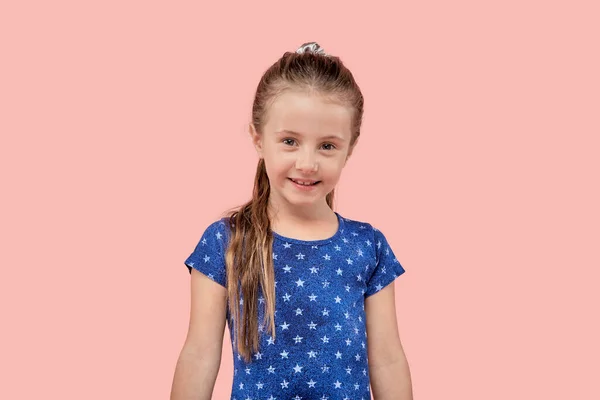 Portret van een lachend mooi meisje kijkend naar de camera op een roze achtergrond. — Stockfoto