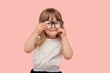 Vizyon için büyük siyah çerçeveli gözlüklü bir kız. Gülümsüyor ve başka tarafa bakıyor..