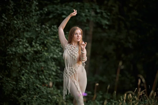 Giovane bella donna che balla nella foresta, mano alzata. — Foto Stock