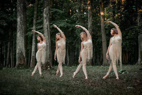 Quatre jeunes danseuses dansent de façon synchrone dans la forêt pieds nus. — Photo