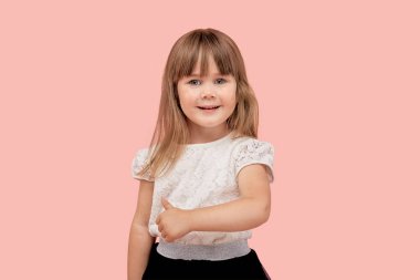 Sevimli güzel kız gülümsüyor ve baş parmak işareti yapıyor, kameraya bakıyor..