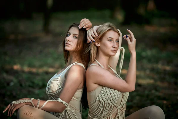 Dos mujeres jóvenes se sientan de espaldas. Mujeres enamoradas. — Foto de Stock