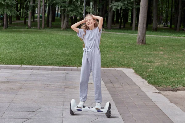 Menina feliz bonita em tênis brancos em uma scooter gyro, hoverboard. — Fotografia de Stock