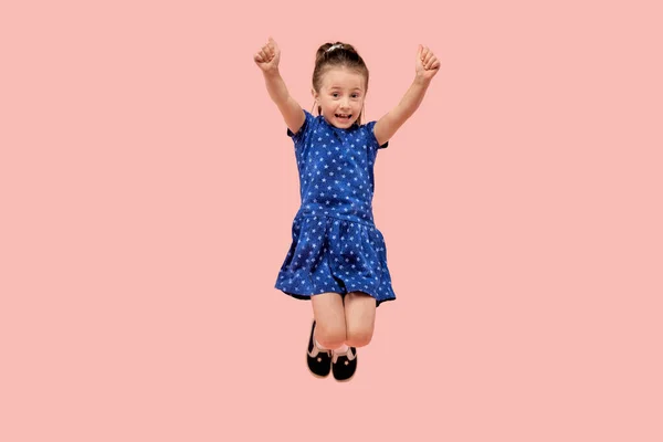 A happy child rejoices in victory with his hands raised up and jumps up. — Stock Photo, Image