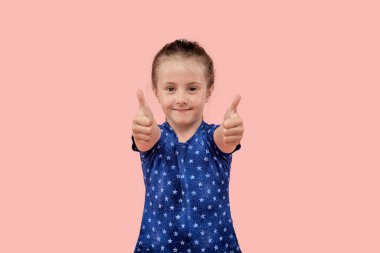 Mavi elbiseli güzel bir kız iki eliyle baş parmak işareti yapıyor..