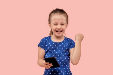 Mutlu bir çocuk zaferle sevinir. Kazanma konsepti. İnsani duygu.