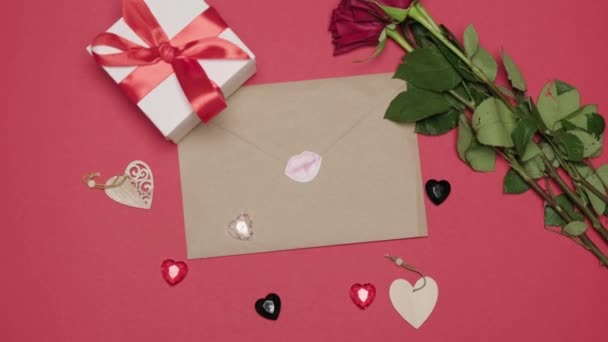Carta de artesanato com um adesivo de beijo em um fundo rosa. Um buquê de rosas vermelhas — Vídeo de Stock