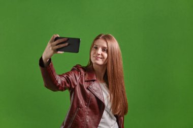 Blogcu güzel bir kadın akıllı telefonuyla selfie çekiyor..