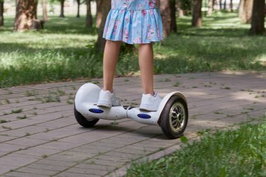 Yaz aylarında spor ayakkabılı kadınlar jiroskopla parkta gezerler..