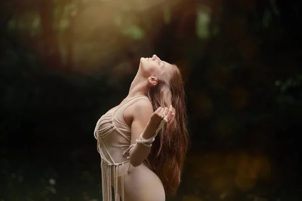 Красивая молодая женщина с натуральным макияжем в лесу смотрит вверх. — стоковое фото