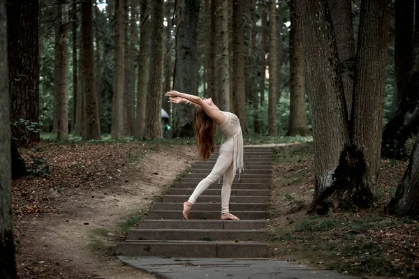 Femme aux cheveux longs dansant dans la nature en été sur des marches en béton. — Photo