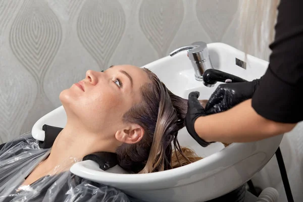 Wash your hair in the washbasin in a beauty salon.